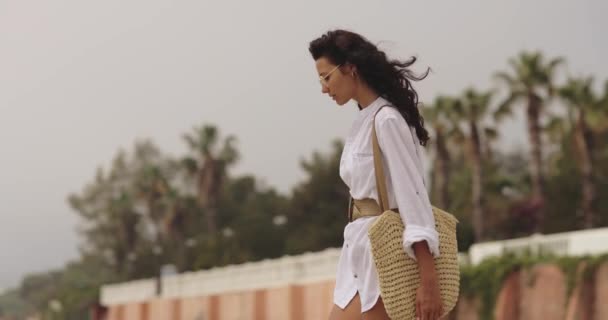 Frau im eleganten Strandoutfit im Sommer draußen vor Palmen im Hintergrund — Stockvideo