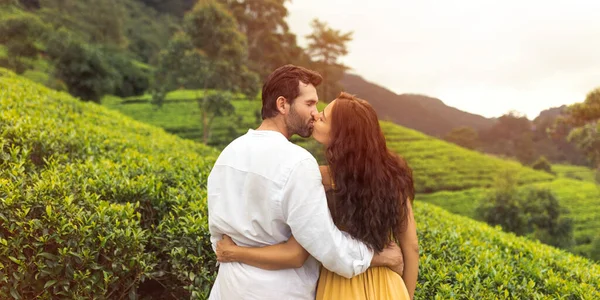 一对浪漫的情侣相亲相爱地站在大自然的背景茶种植园和亲吻 年轻的黑发女人和男人在完美的自然景观前的倒影 — 图库照片