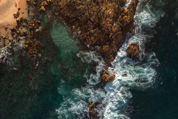 Aerial view Top down seashore big wave crashing on rock cliff Beautiful dark sea surface in sunny day summer background Amazing seascape top view seacoast at Phuket Thailand. High quality photo