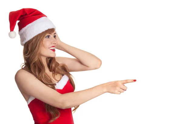 Surprised christmas woman wearing a santa hat shows on copyspace — Stock Photo, Image