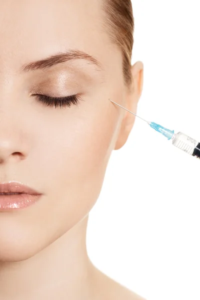 Beautiful woman gets an injection in her face isolated on white — Stock Photo, Image