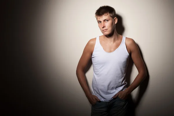 Attractive man wearing t-shirt - portrait on gray background. — Stock Photo, Image