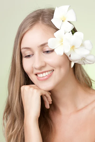 Retrato de mulher atraente com flor sorrindo — Fotografia de Stock