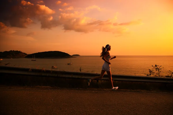 Jonge vrouw uitgevoerd bij zonsondergang — Stockfoto