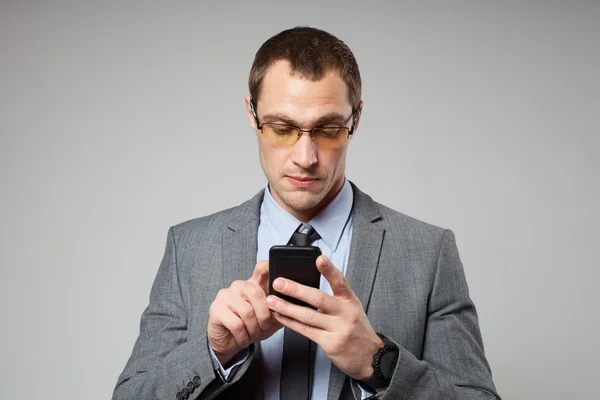 Joven hombre de negocios usando un teléfono móvil — Foto de Stock