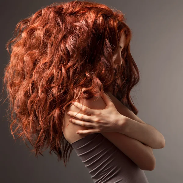 Mulher bonita com penteado encaracolado contra fundo cinza — Fotografia de Stock