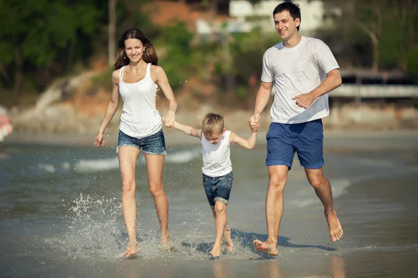 Junge Familie spielt am Strand — Stockfoto