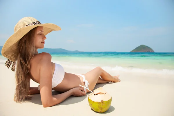 Mladá žena uvolňující na tropické pláži — Stock fotografie