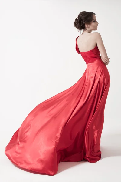 Mujer joven belleza en vestido rojo revoloteando . — Foto de Stock