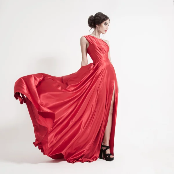 Jovem mulher de beleza em fluttering vestido vermelho . Fotografias De Stock Royalty-Free