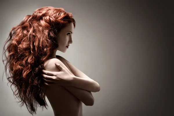 Mulher bonita com penteado encaracolado contra fundo cinza — Fotografia de Stock