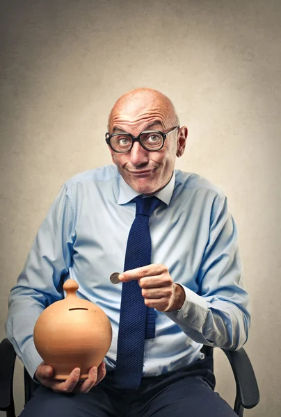 Businessman saving his coin in his piggy bank — Stock Photo, Image
