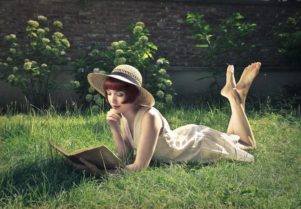 Retro woman reading in the field — Stock Photo, Image