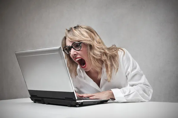 Mulher de negócios gritando contra seu laptop — Fotografia de Stock