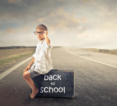 bavula oturan çocuk