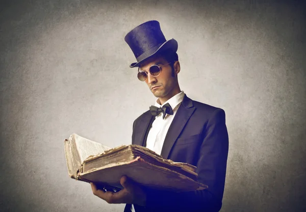 Young man wearing vintage clothes reading an old book — Stock Photo, Image