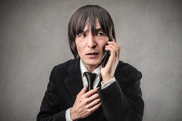 Ledsen affärsman pratar i telefonen — Stockfoto