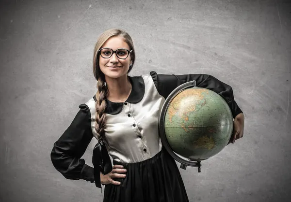 Sonriente joven estudiante sosteniendo un globo — Foto de Stock