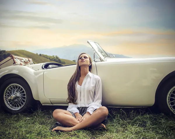 Beautiful woman relaxing by her car — Stock Photo, Image