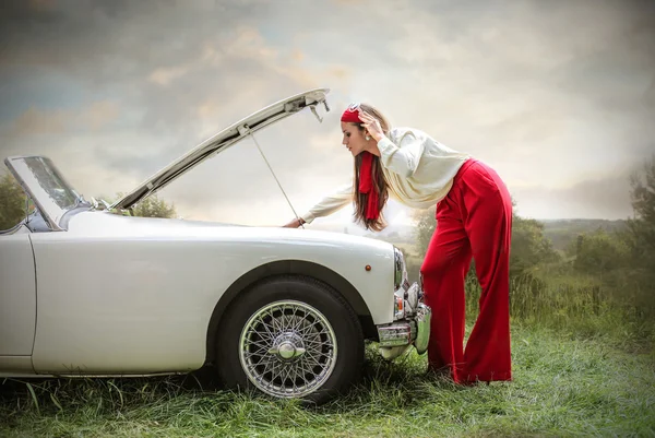 Jeune femme vérifiant le moteur cassé — Photo