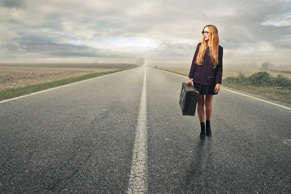 Mujer de moda esperando con una maleta — Foto de Stock