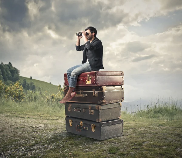 Man looking through a binoculars — Stock Photo, Image