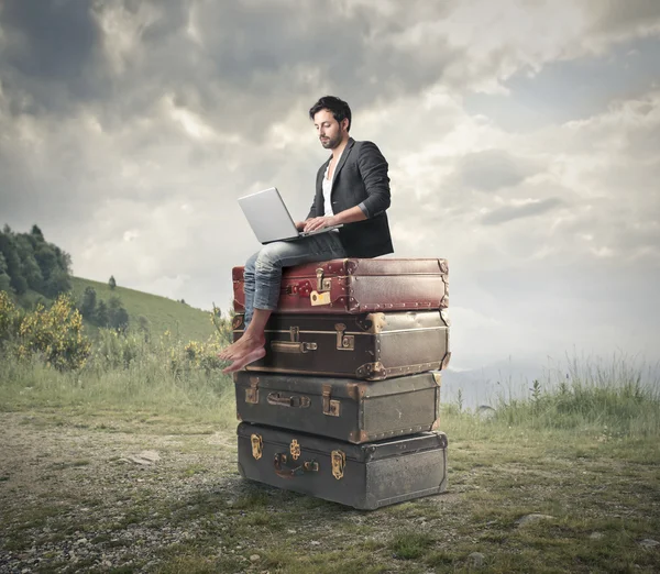 Człowiek siedzi na książkach ogromne — Zdjęcie stockowe
