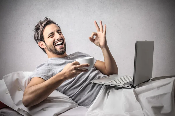 Hombre sonriendo mientras trabaja — Foto de Stock