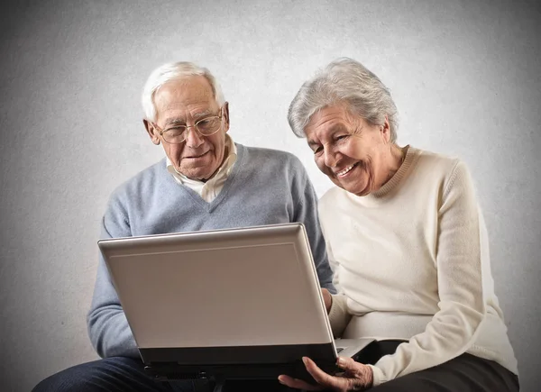 Oude man en vrouw met behulp van een laptop — Stockfoto