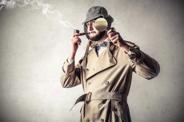 Detektiv raucht und eine Leihgabe benutzt — Stockfoto