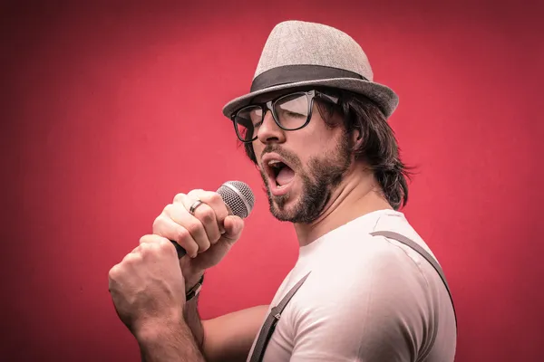 Hombre guapo cantando con un micrófono — Foto de Stock