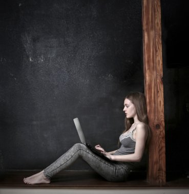 Dizüstü bilgisayarını kullanan genç bir kadın.