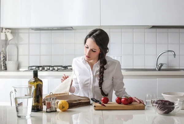 Young woman reading a cookbook — Stock Photo, Image