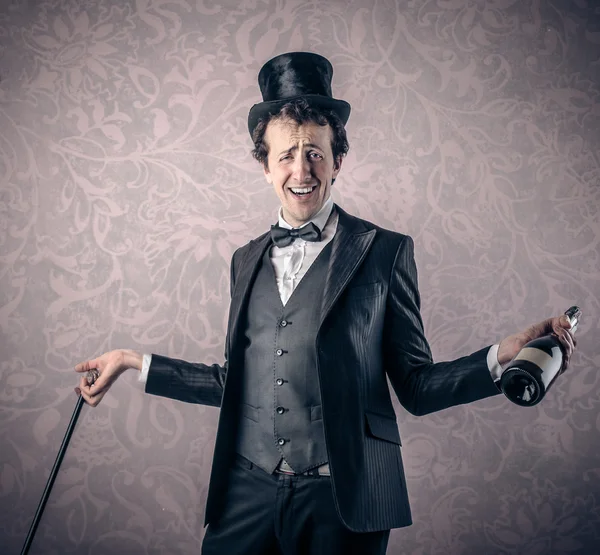 Elegante hombre inteligente con una botella de champán — Foto de Stock