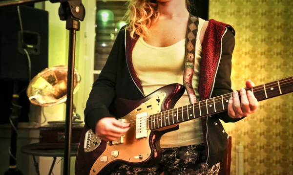 Mujer joven tocando la guitarra elétrica — Foto de Stock