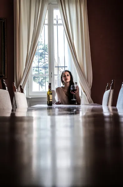 Jovem mulher sentada à mesa — Fotografia de Stock