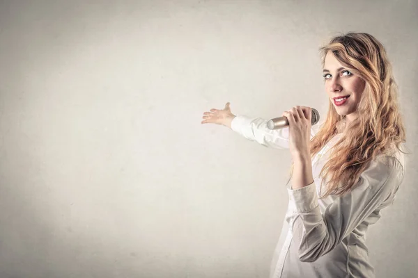 Mujer joven con un micrófono — Foto de Stock