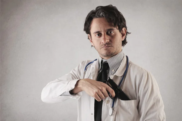 Serious doctor with a gun — Stock Photo, Image