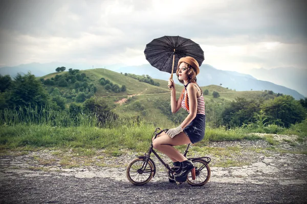 Mujer montando una bicicleta pequeña — Foto de Stock