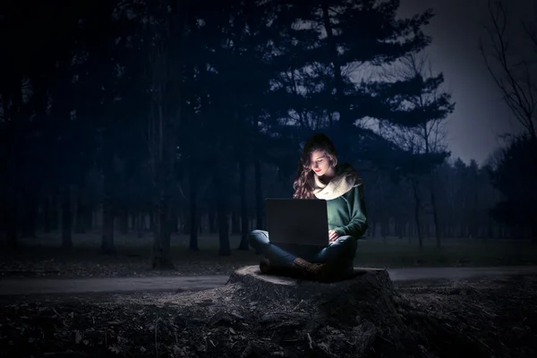 Jovem mulher usando seu laptop durante a noite — Fotografia de Stock