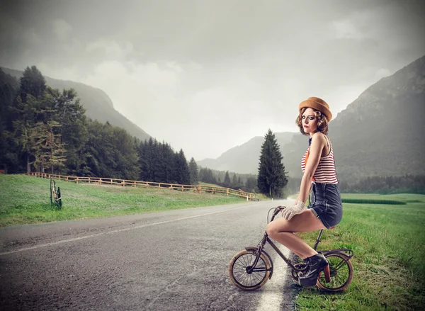 Mujer joven en una bicicleta pequeña — Foto de Stock