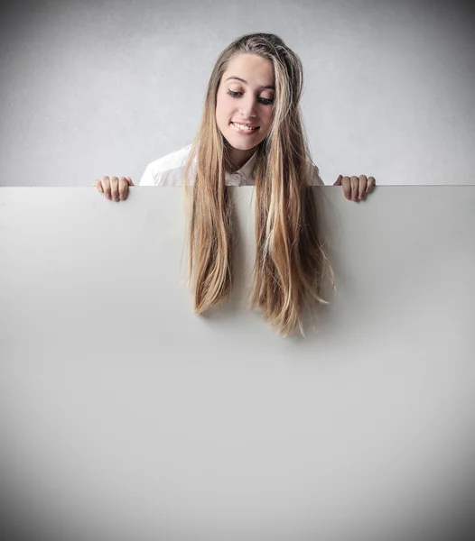 Молода жінка дивиться білий папір — стокове фото