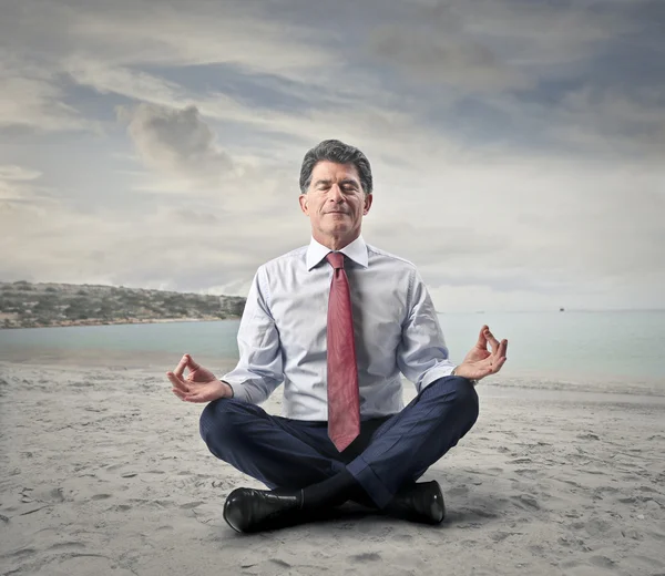 Affärsman gör några yoga på havet — Stockfoto