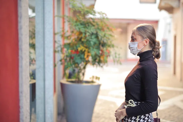 Maskeli Genç Bir Kadın Dükkan Penceresinin Önünde — Stok fotoğraf