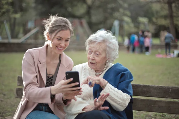 Young Woman Teaches Old Woman Use Smartphone — стоковое фото