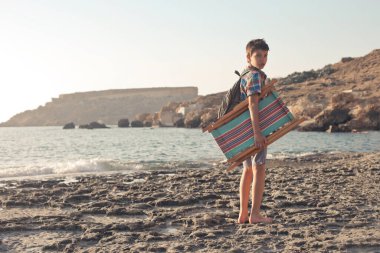Sahilde şezlonglu genç bir çocuk