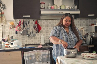 Siyah kadın mutfakta yemek hazırlıyor.