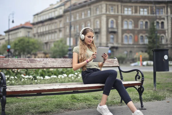 Mujer Joven Con Una Tableta Banco — Foto de Stock