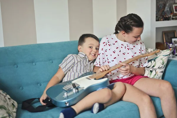 Duas Crianças Brincam Com Uma Guitarra Elétrica — Fotografia de Stock