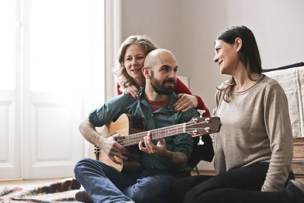 Gitarlı bir grup arkadaş evde eğleniyor.